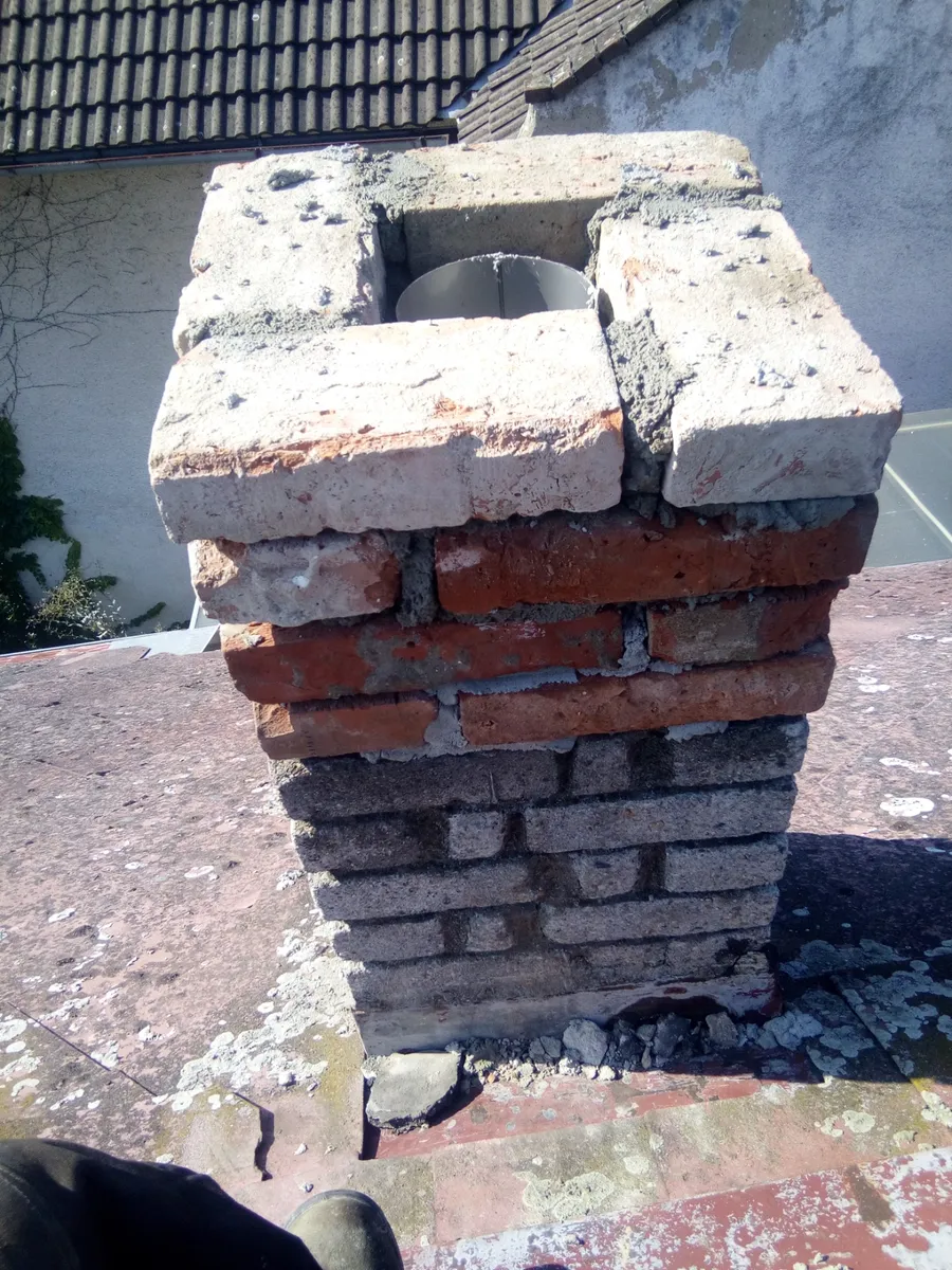 Detail zvětralé cihlové komínové hlavy s bílou krycí deskou